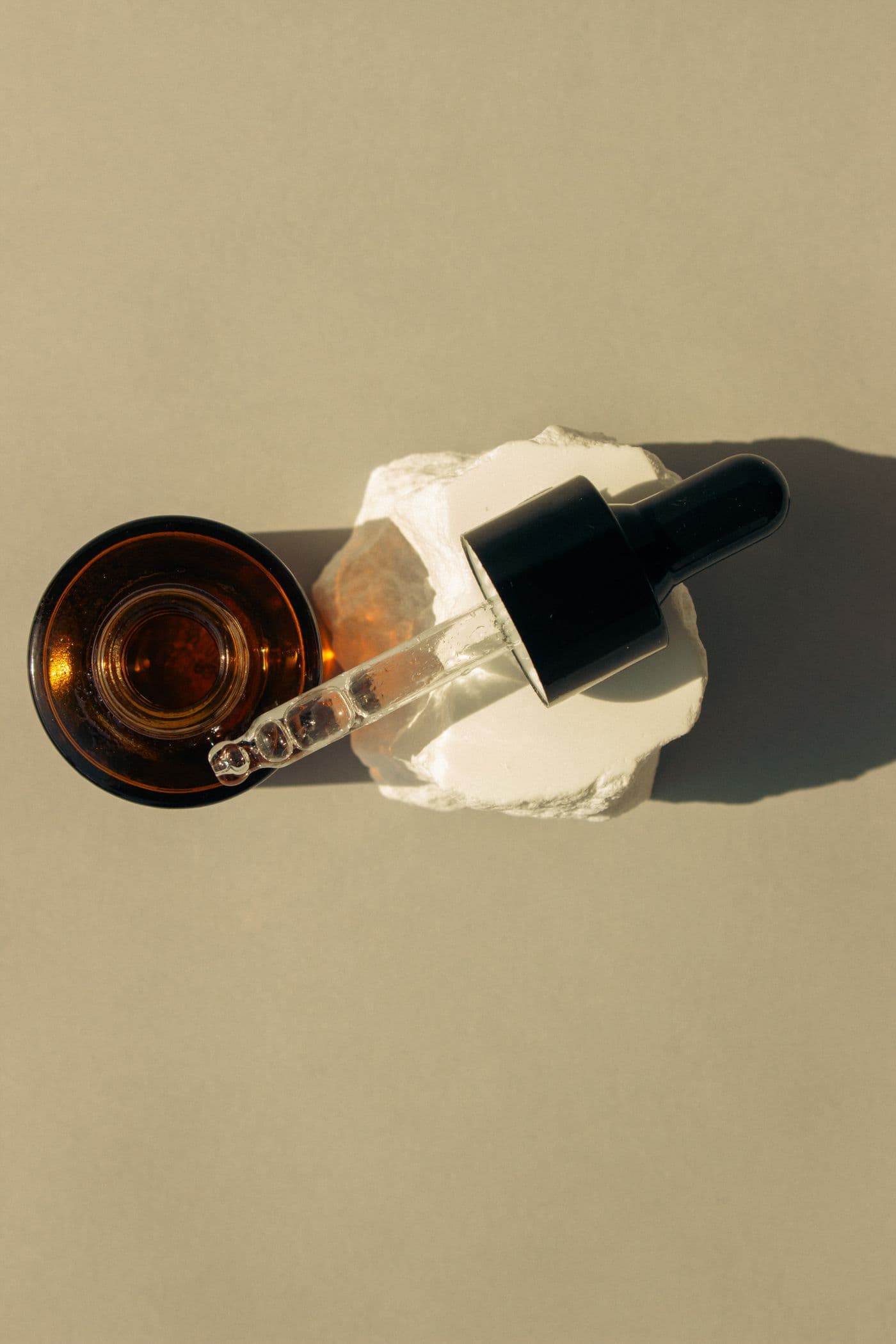 Amber glass dropper bottle of Moss Repair Serum resting on a folded cloth against a warm neutral background.